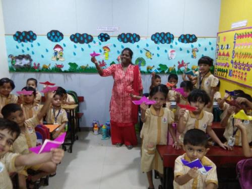 14 Junior KG students doing an activity on the monsoons
